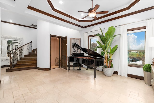 living area featuring baseboards, a tray ceiling, stairs, and crown molding