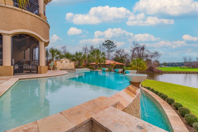 pool with a yard, a patio, and a water view