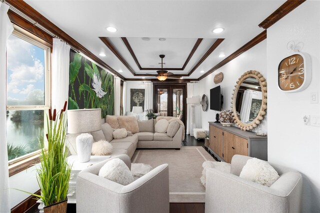 living room with a raised ceiling, wood finished floors, crown molding, french doors, and recessed lighting