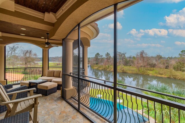 sunroom / solarium featuring a healthy amount of sunlight, a water view, and ceiling fan