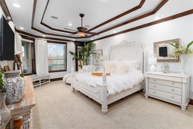 bedroom with light carpet, a raised ceiling, visible vents, and crown molding