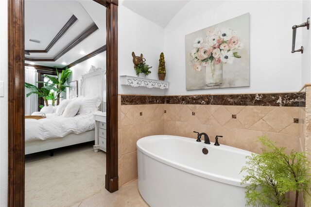 bathroom with tile walls, a soaking tub, ornamental molding, wainscoting, and connected bathroom