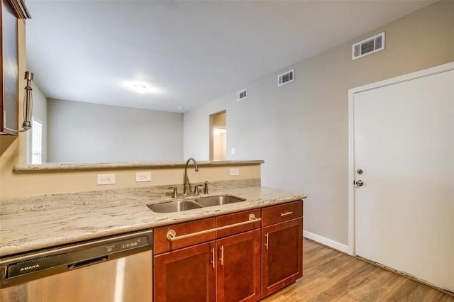 kitchen with dishwasher, sink, light stone counters, and light hardwood / wood-style flooring