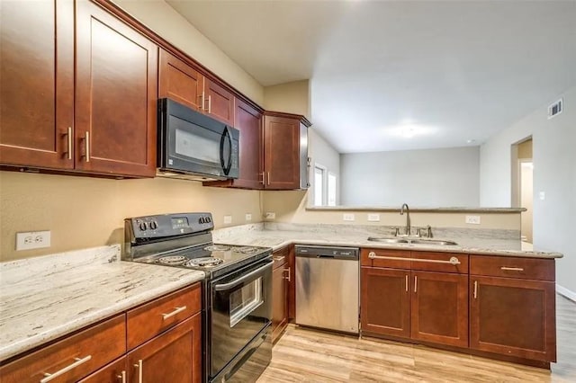 kitchen featuring sink, light stone counters, kitchen peninsula, light hardwood / wood-style floors, and black appliances