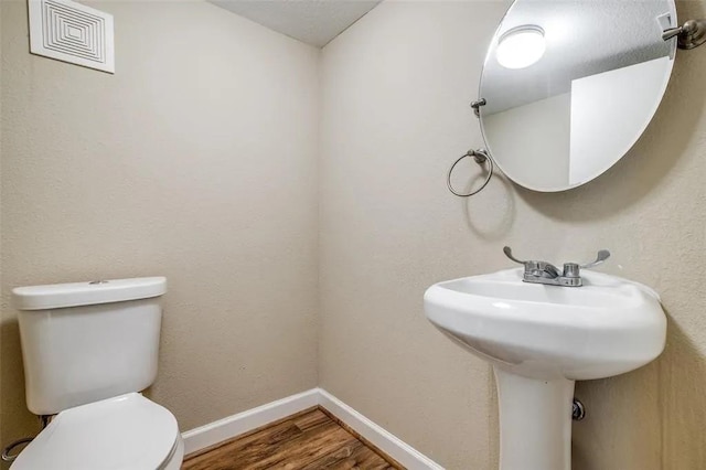 bathroom featuring hardwood / wood-style floors and toilet