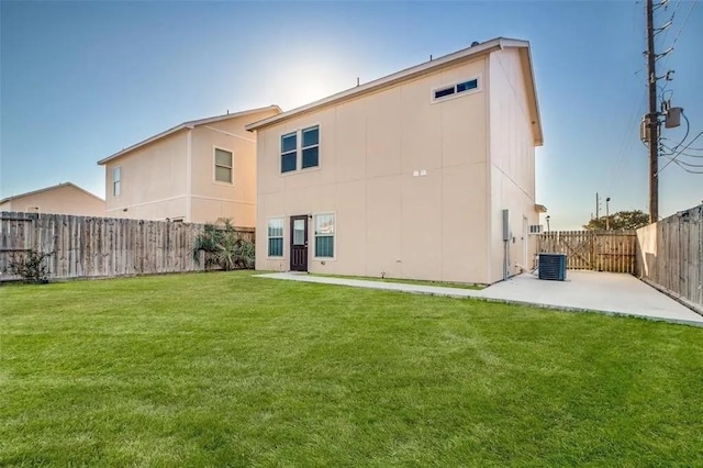 rear view of property with a patio area, central air condition unit, and a lawn