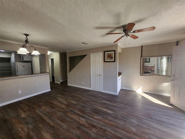 unfurnished living room with dark wood-type flooring, ceiling fan, ornamental molding, and a textured ceiling