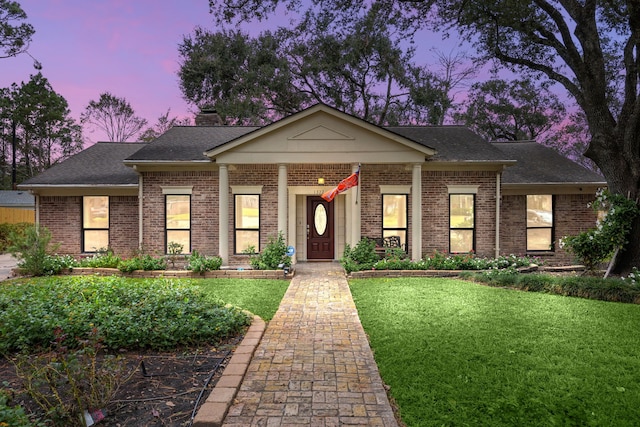 view of front of home featuring a porch and a yard