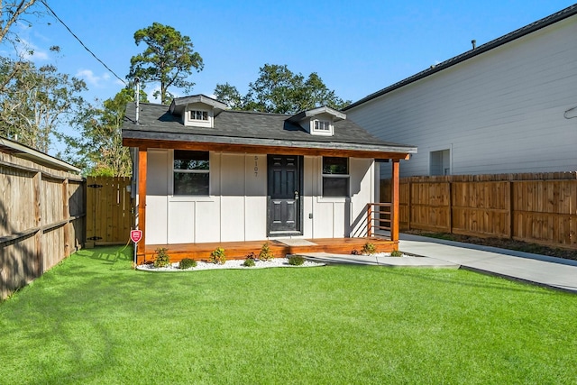 rear view of property featuring a porch and a yard