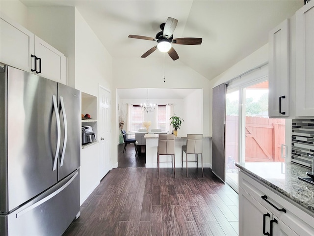 kitchen featuring white cabinetry, dark wood-type flooring, stainless steel fridge, light stone countertops, and tasteful backsplash