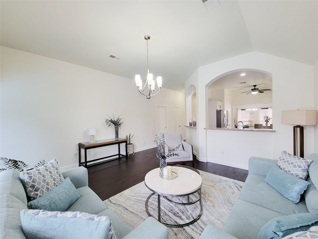 living room with vaulted ceiling, dark hardwood / wood-style floors, and ceiling fan with notable chandelier