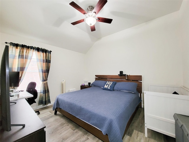 bedroom featuring ceiling fan, hardwood / wood-style flooring, and lofted ceiling