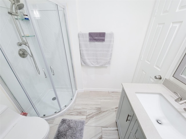 bathroom with vanity, toilet, and a shower with shower door