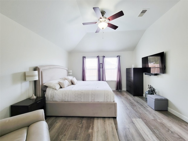 bedroom featuring light hardwood / wood-style floors, lofted ceiling, and ceiling fan