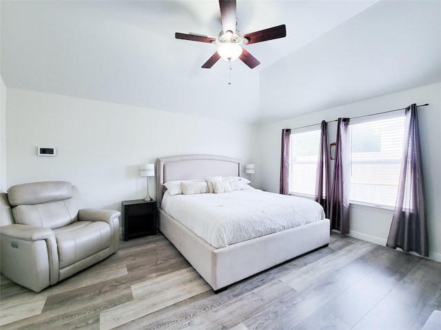 bedroom featuring light hardwood / wood-style floors, vaulted ceiling, and ceiling fan