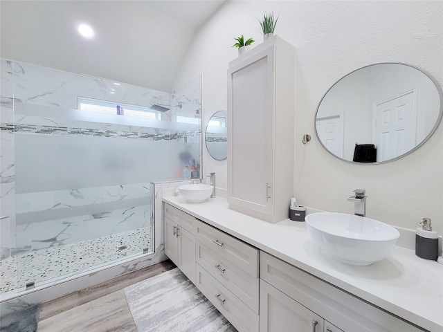 bathroom with vanity, hardwood / wood-style floors, lofted ceiling, and tiled shower