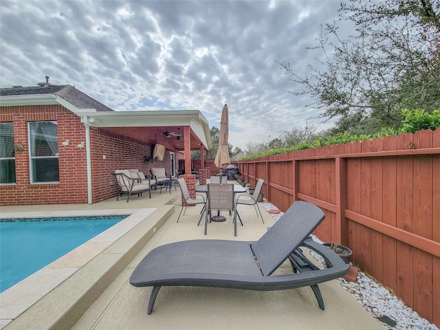 view of swimming pool featuring ceiling fan and a patio area