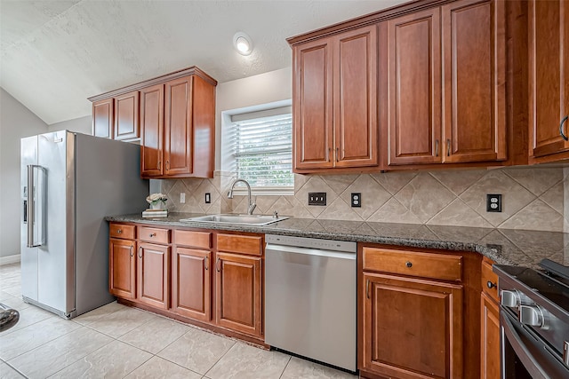 kitchen with sink, backsplash, stainless steel appliances, light tile patterned flooring, and vaulted ceiling