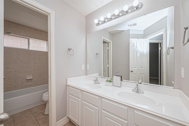 full bathroom featuring tile patterned flooring, vanity, tiled shower / bath combo, and toilet