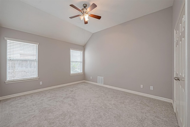 spare room featuring vaulted ceiling, light colored carpet, and ceiling fan