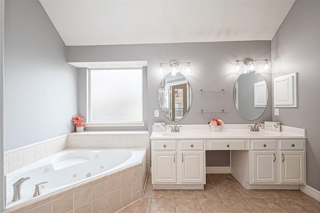 bathroom with vanity, tiled tub, and tile patterned flooring