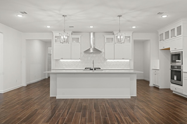 906 Hooks Trl, League City, TX 77573 - kitchen featuring wall chimney range hood, decorative light fixtures, a center island with sink, and appliances with stainless steel finishes