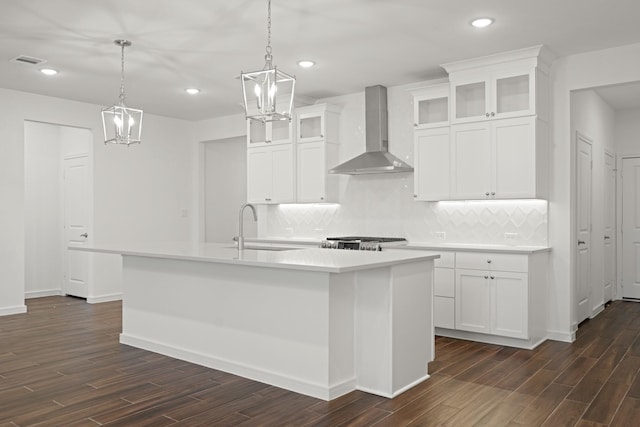 906 Hooks Trl, League City, TX 77573 - kitchen with sink, white cabinetry, an island with sink, decorative light fixtures, and wall chimney exhaust hood