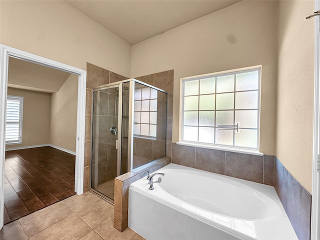 bathroom with a wealth of natural light, tile patterned floors, and plus walk in shower