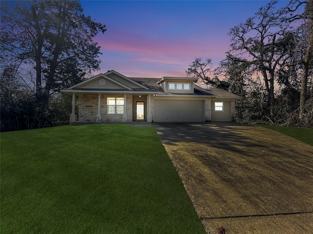 view of front of home with a garage and a lawn