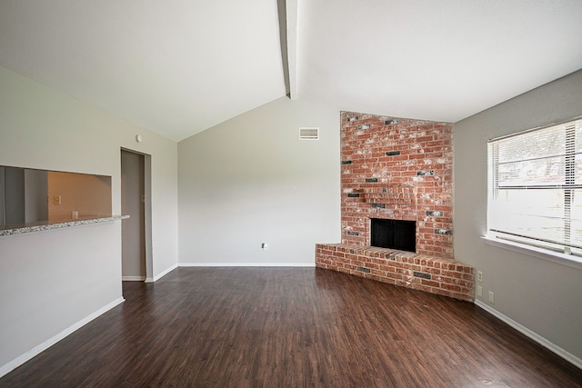 unfurnished living room with a brick fireplace, dark hardwood / wood-style floors, and lofted ceiling