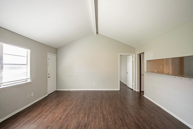 empty room featuring dark hardwood / wood-style floors and vaulted ceiling with beams