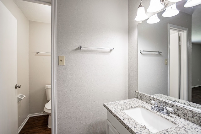 bathroom featuring vanity, toilet, a chandelier, and hardwood / wood-style floors