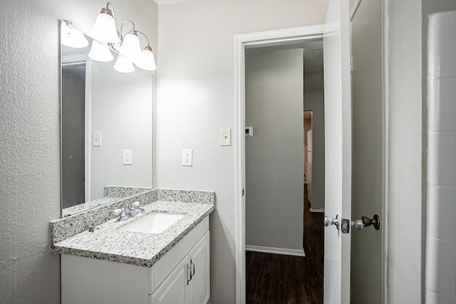 bathroom with vanity, hardwood / wood-style floors, and a notable chandelier