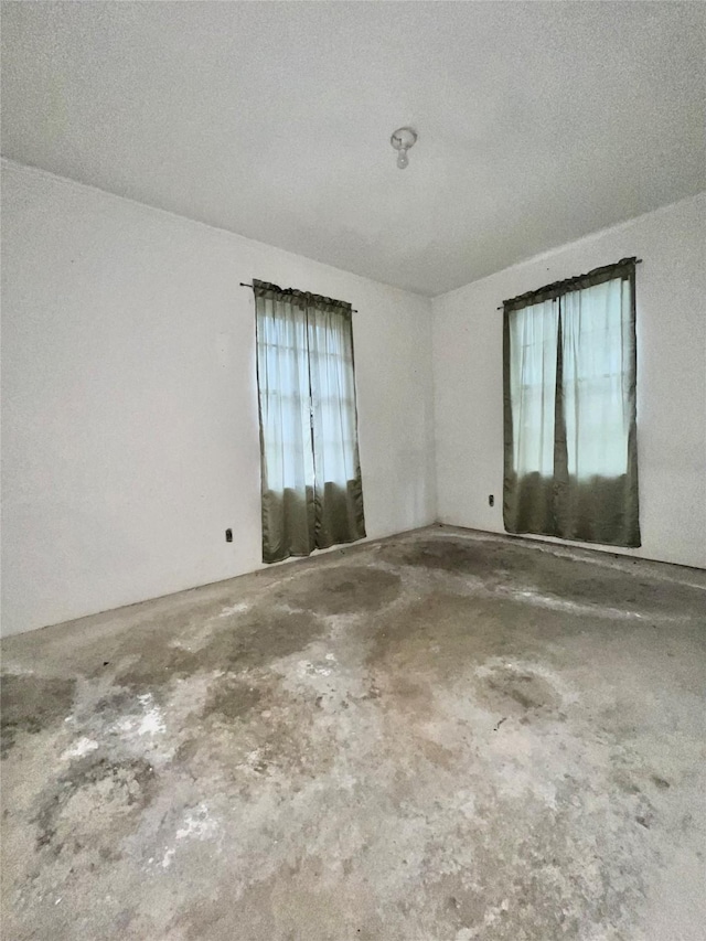 unfurnished room featuring concrete flooring