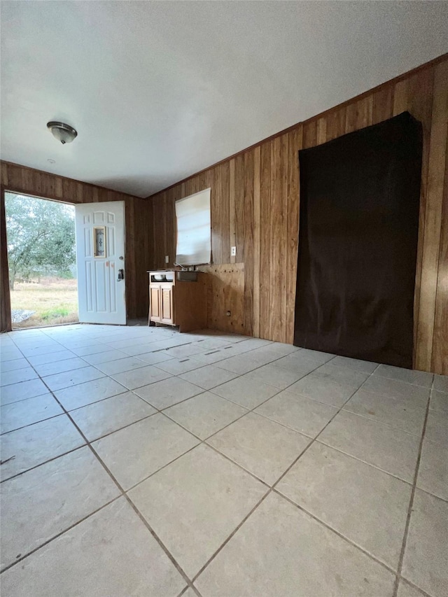 interior space featuring light tile patterned floors and wood walls