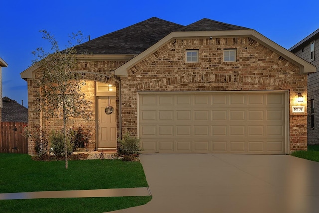 view of front of property with a yard and a garage