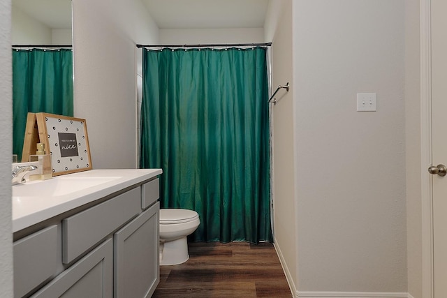 bathroom featuring vanity, hardwood / wood-style floors, walk in shower, and toilet