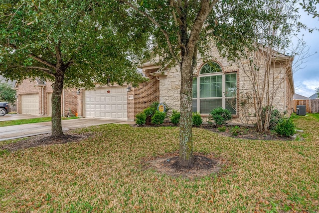 obstructed view of property with concrete driveway, brick siding, a front yard, and central air condition unit