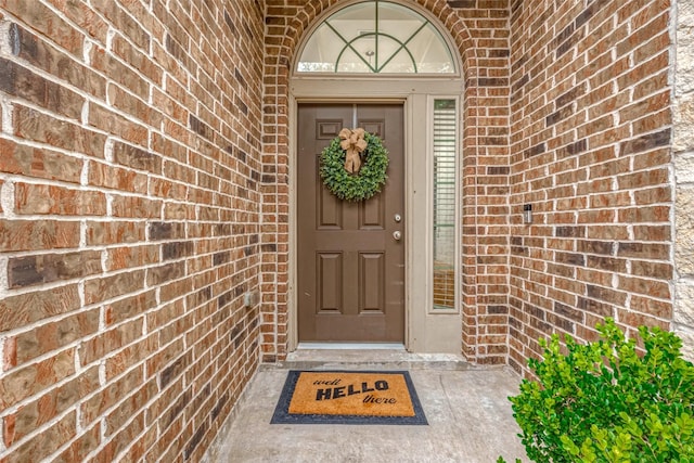 view of exterior entry featuring brick siding