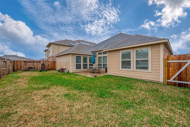 rear view of property featuring a fenced backyard, a shingled roof, a patio, and a yard