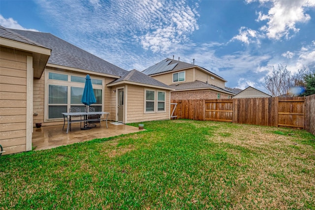 rear view of property with a patio, a yard, and a fenced backyard