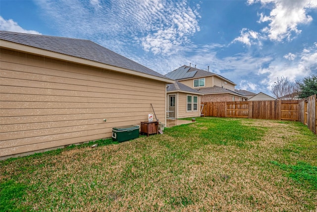 back of house featuring a yard and a fenced backyard