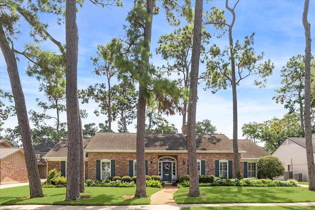 view of front of house with brick siding and a front yard