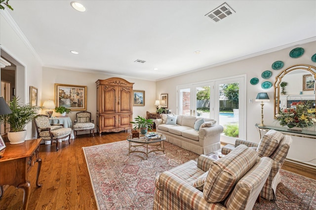 living area featuring recessed lighting, wood finished floors, visible vents, and ornamental molding