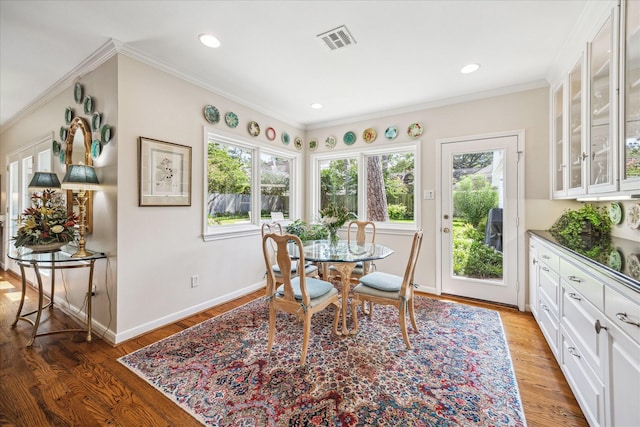 dining space featuring light wood finished floors, visible vents, baseboards, ornamental molding, and recessed lighting