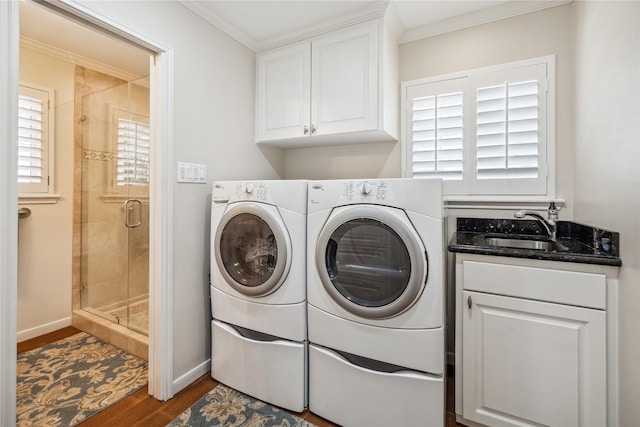 washroom with independent washer and dryer, a sink, dark wood-style floors, cabinet space, and baseboards