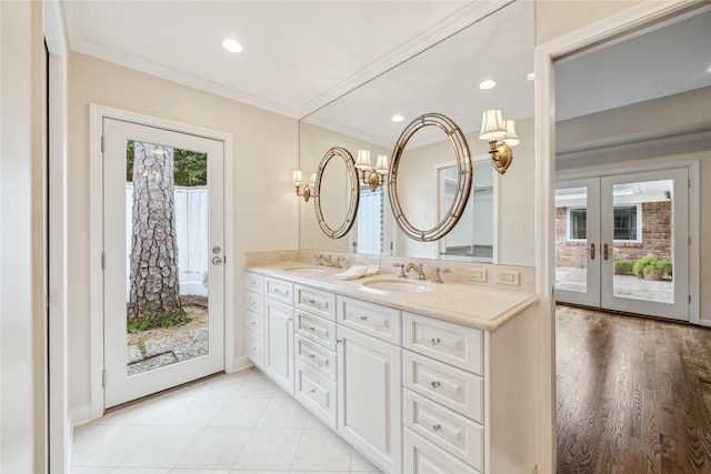 bathroom featuring double vanity, ornamental molding, french doors, and a sink