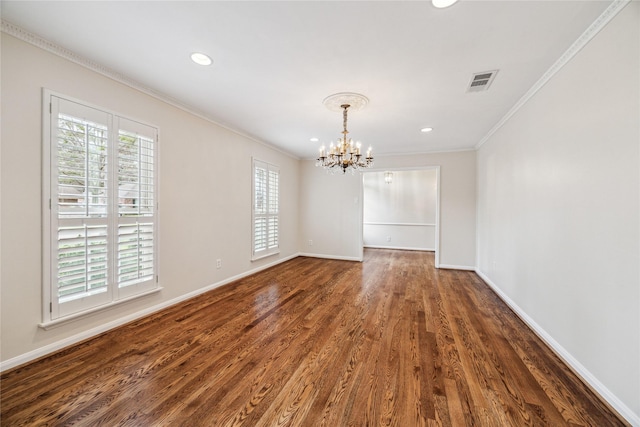 spare room featuring visible vents, dark wood-type flooring, crown molding, baseboards, and a chandelier