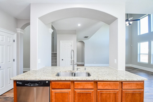 kitchen with sink, ceiling fan, light stone countertops, stainless steel dishwasher, and light wood-type flooring