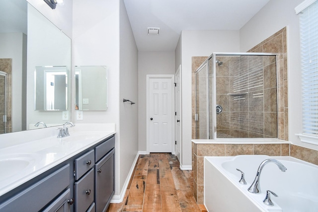 bathroom featuring wood-type flooring, vanity, and plus walk in shower